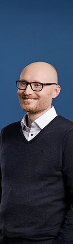 Portrait eines ACV Service-Mitarbeiters vor buntem Hintergrund