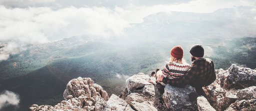 Zwei Personen schauen sich eine Berglandschaft an